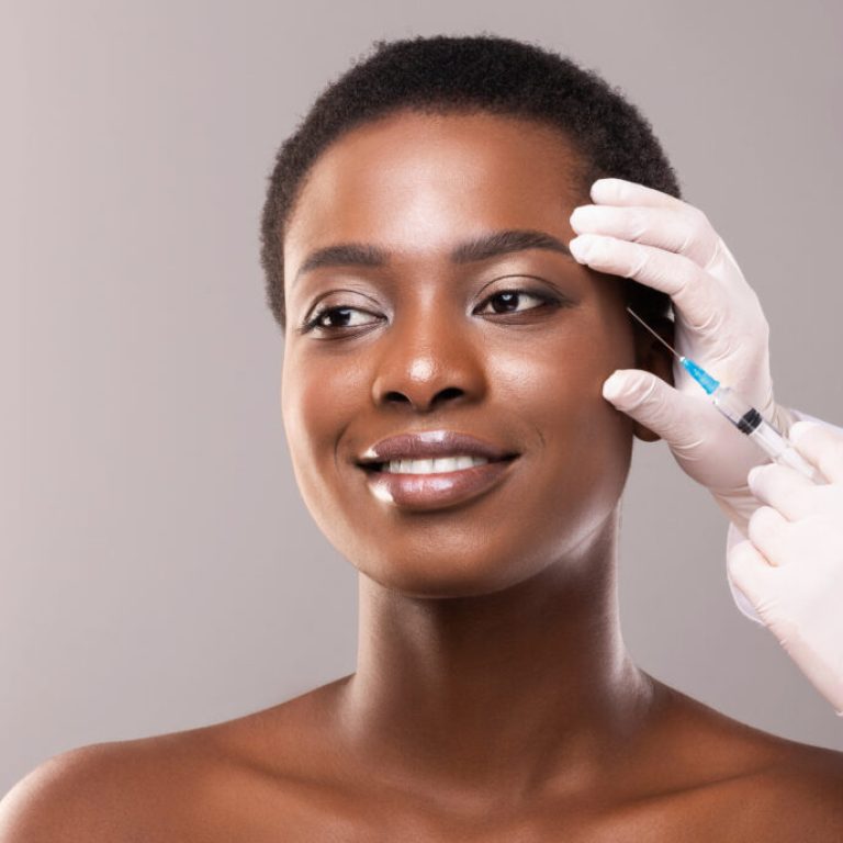 Beauty injection. Beautiful black woman making plastic surgery procedure for face